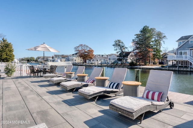 view of patio / terrace with a residential view, a boat dock, and a water view