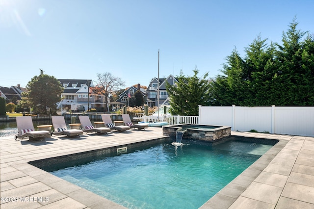 view of swimming pool with a residential view, a pool with connected hot tub, a fenced backyard, and a patio area