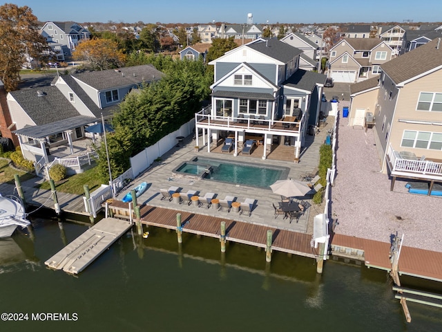 rear view of property featuring a fenced in pool, a water view, a residential view, a fenced backyard, and a patio