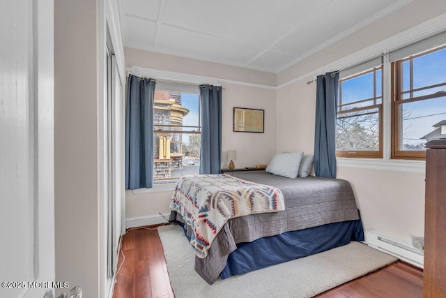 304 8th Ave, Asbury Park, NJ 07712 - bedroom with baseboard heating, wood finished floors, and crown molding
