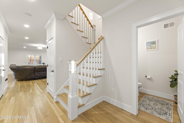 staircase with visible vents, baseboards, ornamental molding, recessed lighting, and wood finished floors
