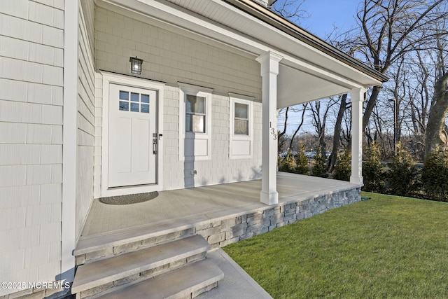 property entrance featuring a lawn and a porch