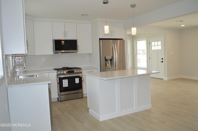 71 Montserrat St, Toms River, NJ 08757 - kitchen featuring appliances with stainless steel finishes, a sink, tasteful backsplash, light wood-style floors, and white cabinetry
