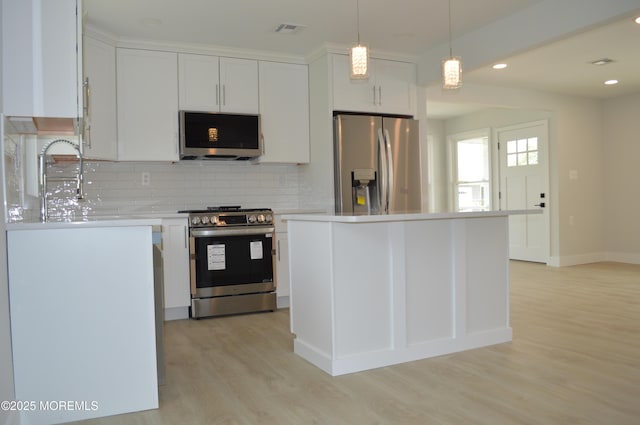 71 Montserrat St, Toms River, NJ 08757 - kitchen with appliances with stainless steel finishes, light wood-style flooring, backsplash, white cabinets, and light countertops