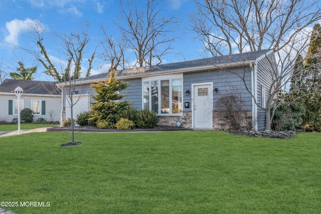 single story home featuring stone siding, a front yard, and a garage