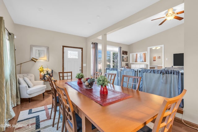 dining space with vaulted ceiling and wood finished floors