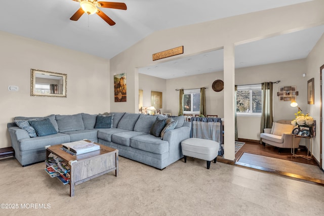 living area with baseboards, a ceiling fan, and lofted ceiling