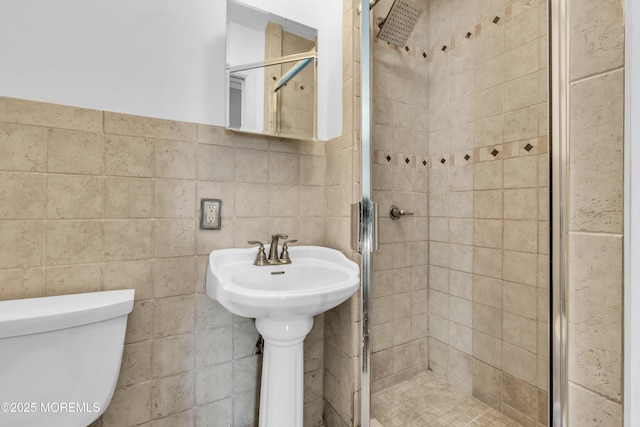 full bathroom with toilet, tile walls, and a stall shower