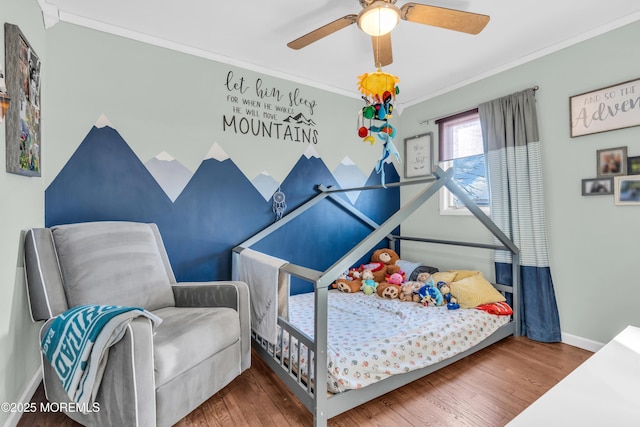 bedroom featuring ceiling fan, wood finished floors, baseboards, and ornamental molding