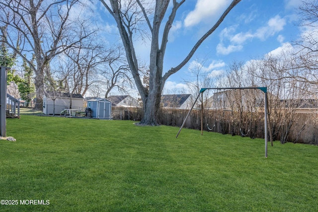 view of yard with an outbuilding, a storage shed, and a fenced backyard