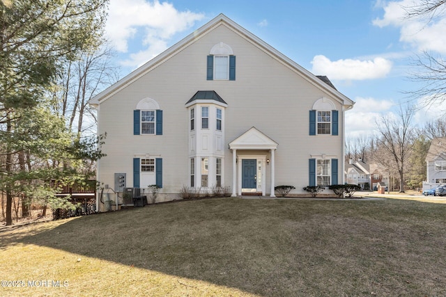 view of front of house with a front lawn and central air condition unit