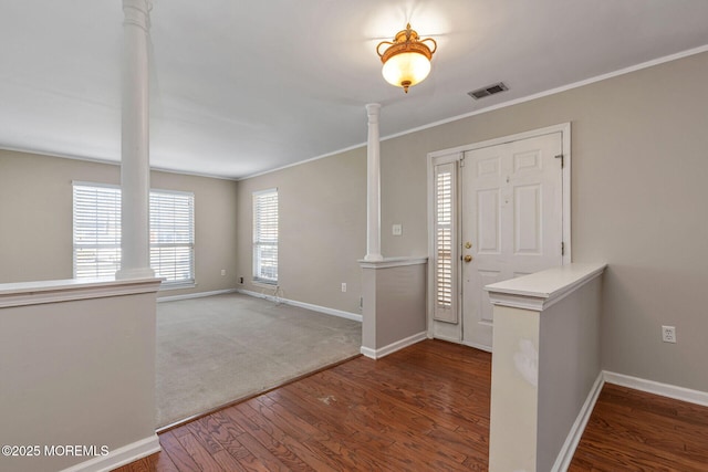 entryway with wood finished floors, visible vents, ornate columns, and baseboards