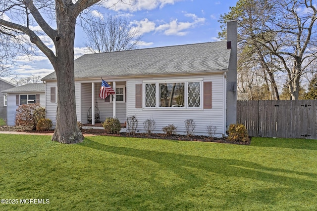 view of front of property featuring a shingled roof, a front yard, fence, and a chimney