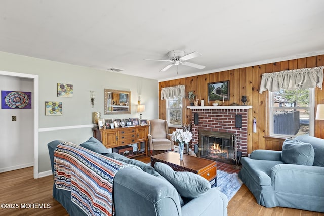 living room with visible vents, a healthy amount of sunlight, wood finished floors, and a fireplace