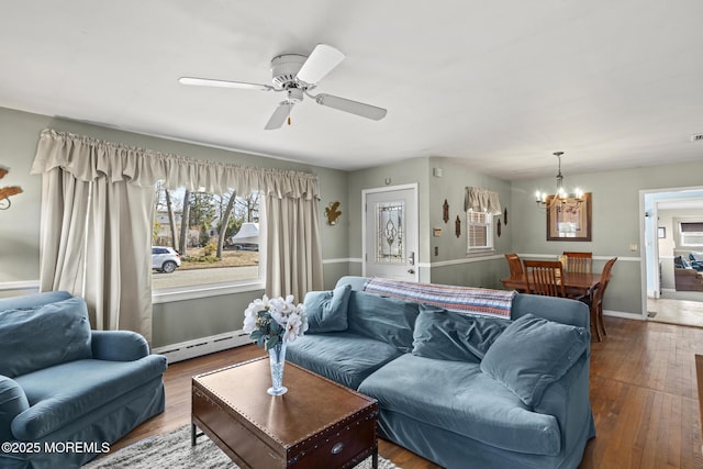 living area with hardwood / wood-style floors, ceiling fan with notable chandelier, baseboards, and a baseboard radiator