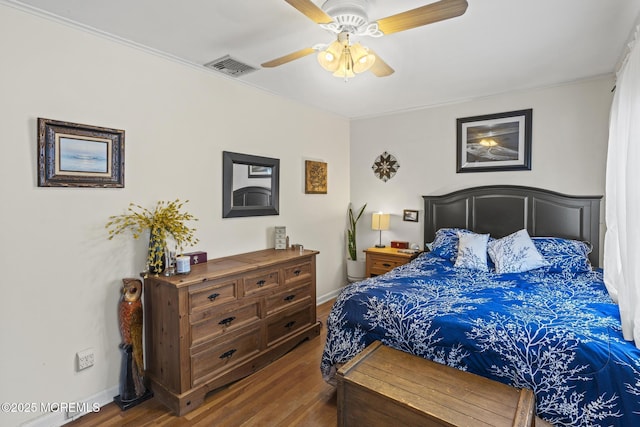 bedroom with visible vents, baseboards, a ceiling fan, and wood finished floors