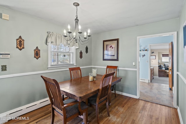 dining room featuring an inviting chandelier, wood-type flooring, baseboards, and baseboard heating