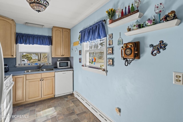 kitchen with light brown cabinetry, a sink, stone finish flooring, white appliances, and baseboards