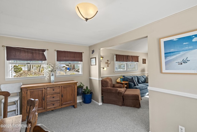 living area with light carpet and baseboards