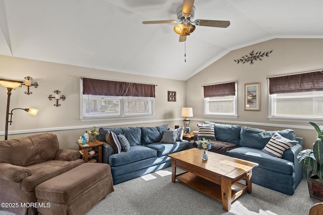 carpeted living area with a wealth of natural light, ceiling fan, and vaulted ceiling