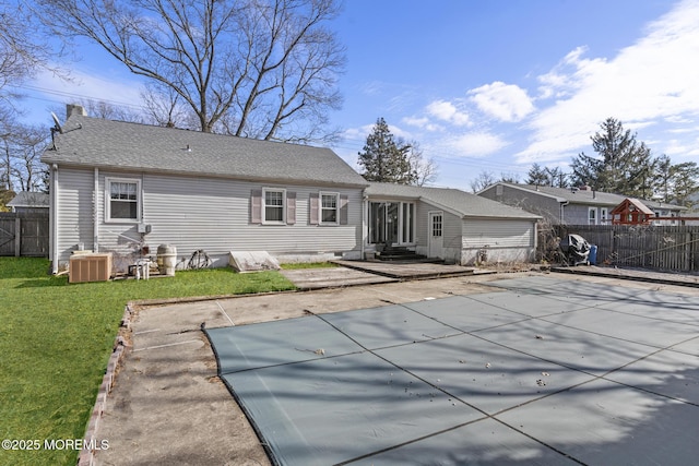 rear view of property with fence, a yard, entry steps, central air condition unit, and a patio area