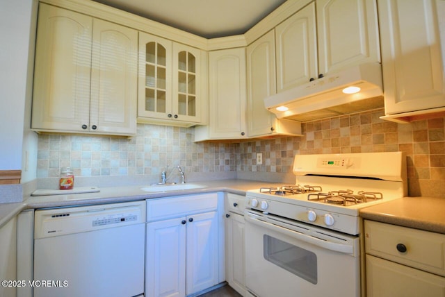 kitchen featuring white appliances, a sink, light countertops, under cabinet range hood, and backsplash