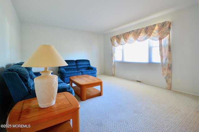 carpeted living area featuring baseboards and visible vents