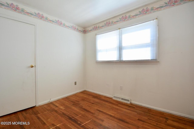 unfurnished room featuring visible vents, baseboards, and wood finished floors