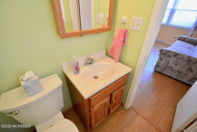 bathroom featuring toilet, wood finished floors, and vanity