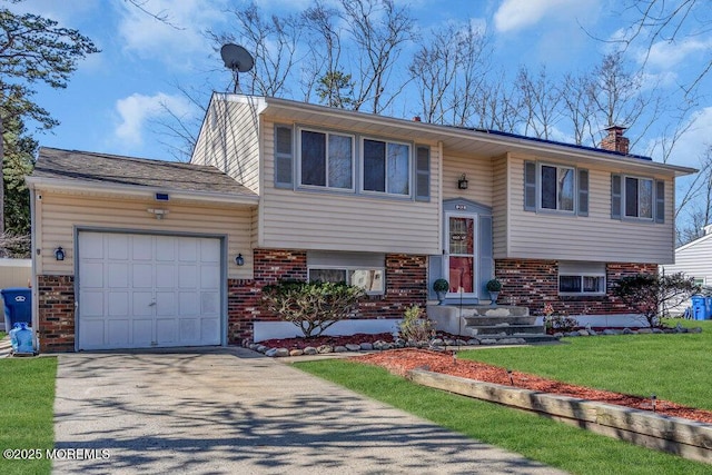 bi-level home featuring brick siding, a front lawn, a chimney, driveway, and an attached garage