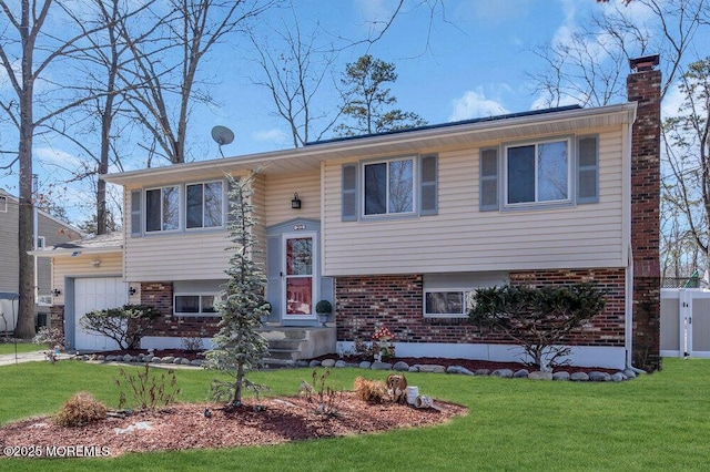 raised ranch with brick siding, a chimney, and a front yard