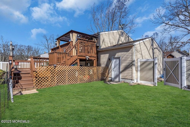 back of property with a gate, a lawn, a deck, and fence