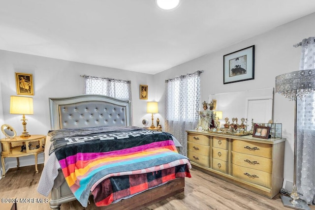 bedroom with multiple windows and wood finished floors