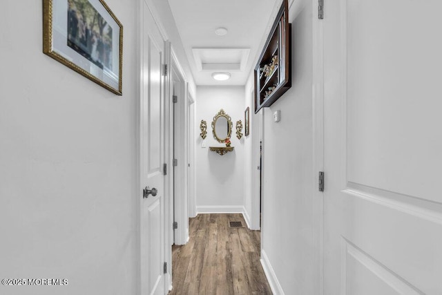 hall featuring attic access, wood finished floors, visible vents, and baseboards