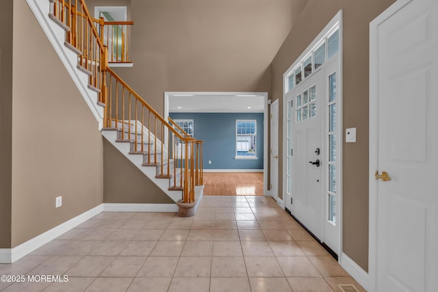 foyer entrance featuring visible vents, baseboards, stairs, and tile patterned flooring