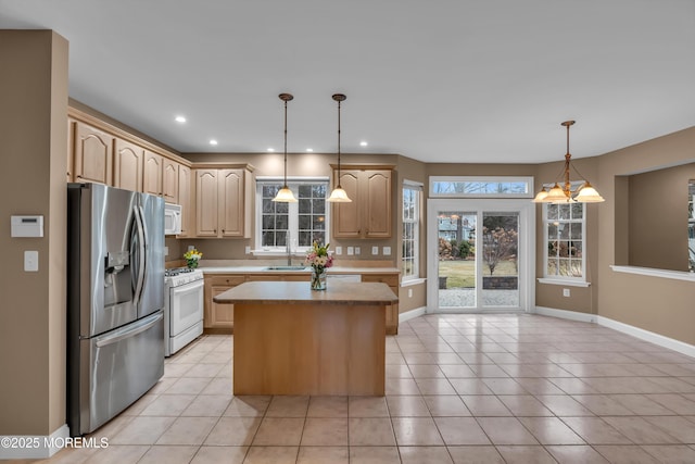 kitchen with light brown cabinets, a center island, light countertops, light tile patterned flooring, and white appliances