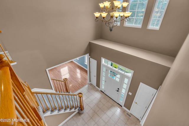 entrance foyer featuring tile patterned floors, stairway, a healthy amount of sunlight, and visible vents