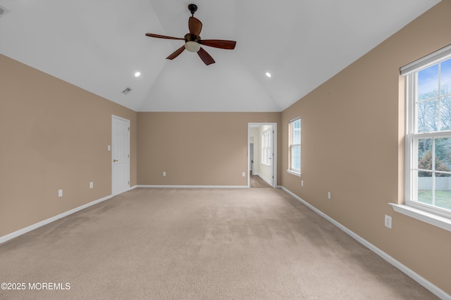 unfurnished room with a wealth of natural light, visible vents, high vaulted ceiling, and baseboards