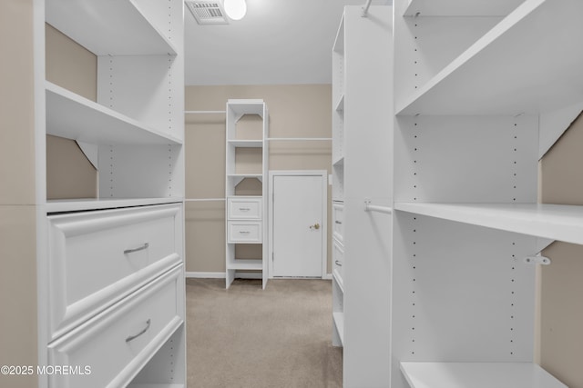 spacious closet with visible vents and light colored carpet