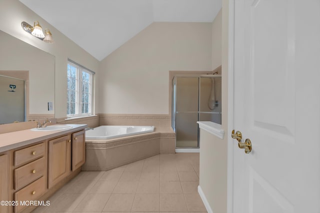 bathroom with tile patterned flooring, a shower stall, vaulted ceiling, a bath, and vanity