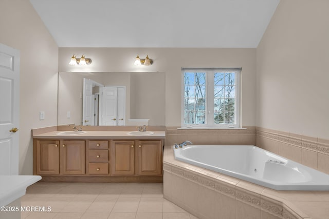 bathroom with a bath, tile patterned flooring, double vanity, and a sink