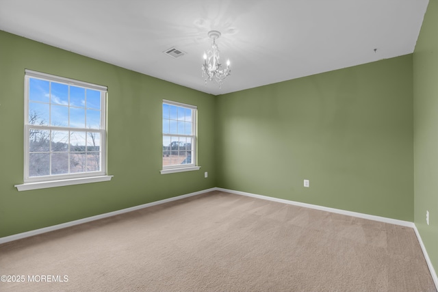 unfurnished room with visible vents, baseboards, carpet, and an inviting chandelier