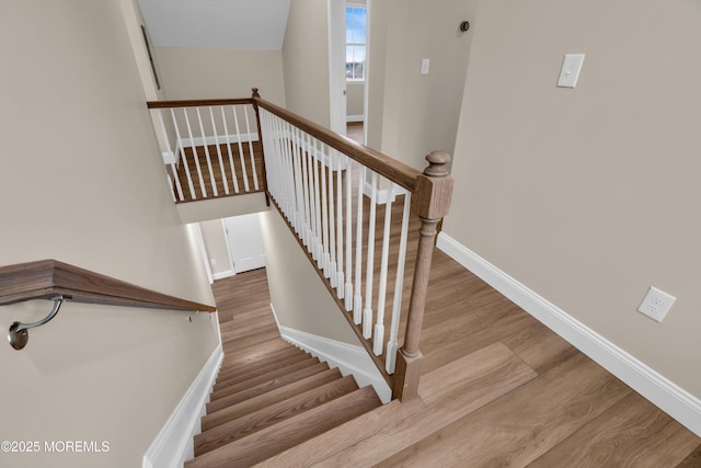 staircase with wood finished floors and baseboards