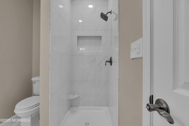 full bath featuring a stall shower and toilet