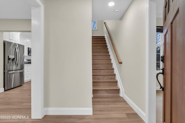 stairs with recessed lighting, baseboards, and wood finished floors