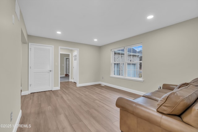 unfurnished living room with recessed lighting, light wood-type flooring, and baseboards