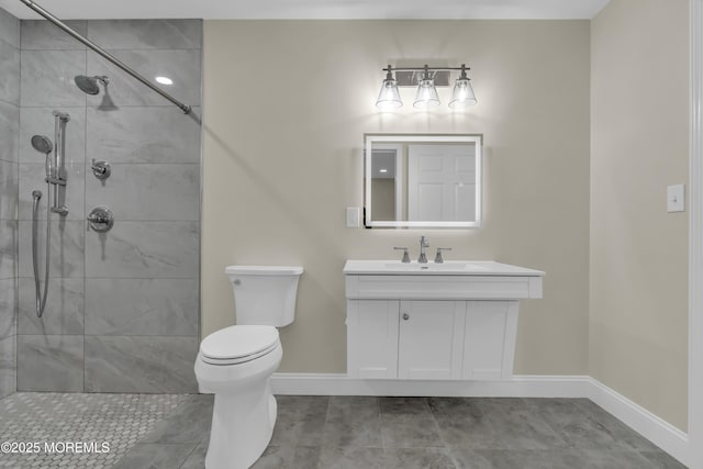 bathroom featuring baseboards, toilet, vanity, and a tile shower