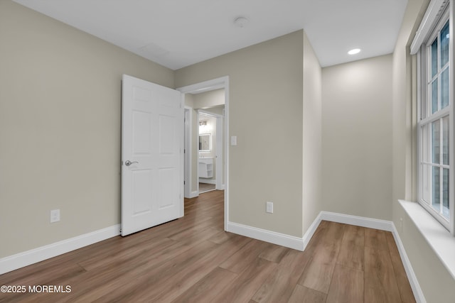 spare room with baseboards, a healthy amount of sunlight, and wood finished floors