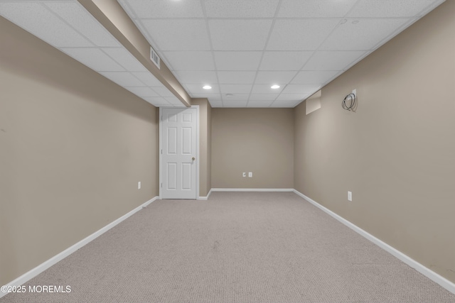 finished below grade area featuring visible vents, carpet, baseboards, a drop ceiling, and recessed lighting