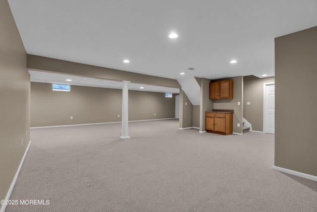 below grade area with light colored carpet, stairs, recessed lighting, and baseboards